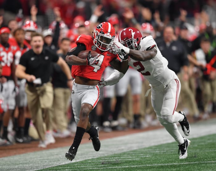 Jan 8, 2018; Atlanta, GA, USA; Georgia Bulldogs wide receiver Mecole Hardman (4) runs for a touchdown after a completion against Alabama Crimson Tide defensive back Tony Brown (2) during the third quarter in the 2018 CFP national championship college football game at Mercedes-Benz Stadium.